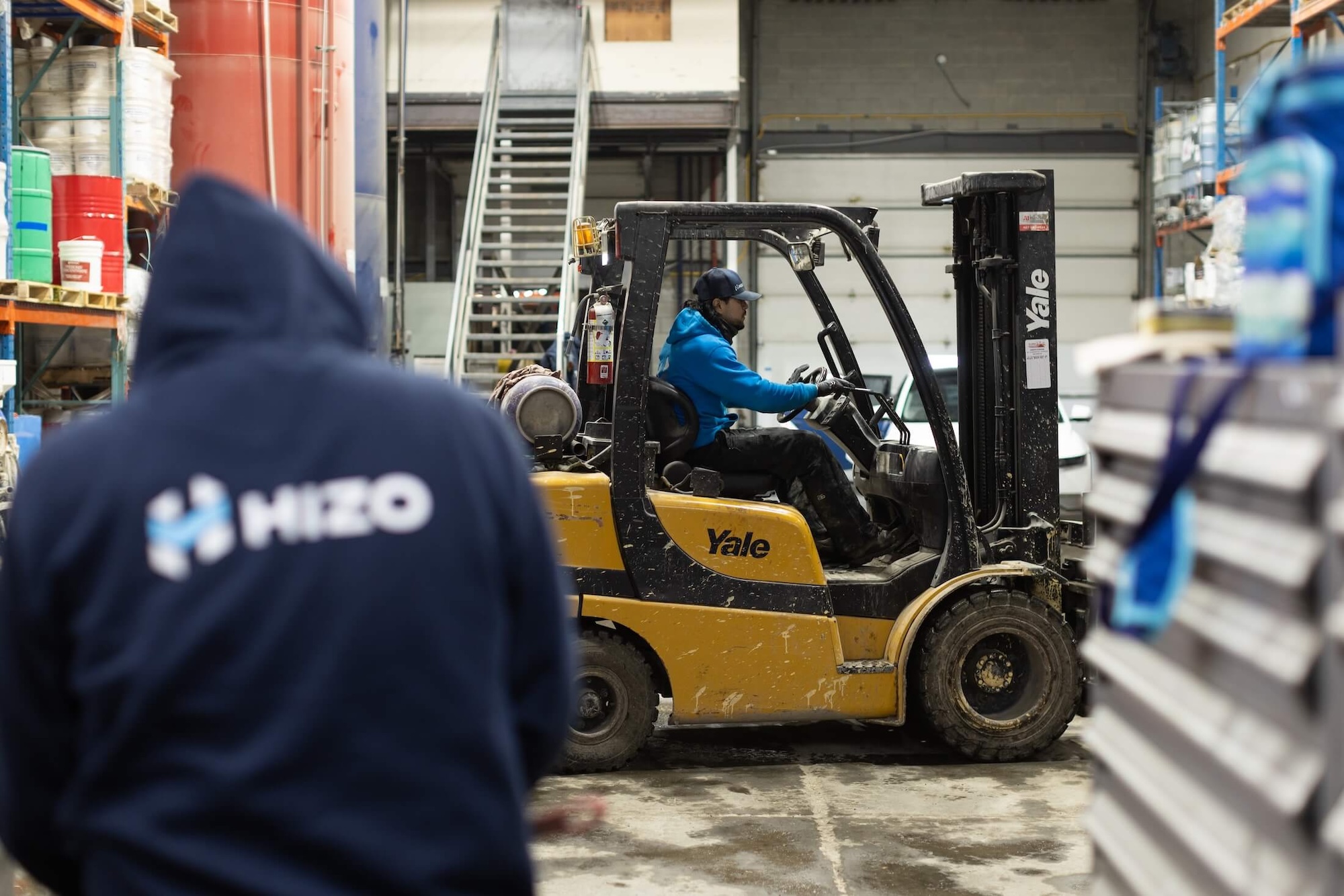 Équipe HIZO en entrepôt préparant le matériel d'isolation